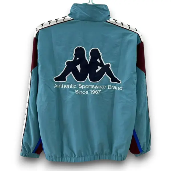 b-akapparetromodelgreenwithbluewindbreakerjacket1-Photoroom-Photoroom.webp Chaqueta Barcelona Retro – Cortavientos